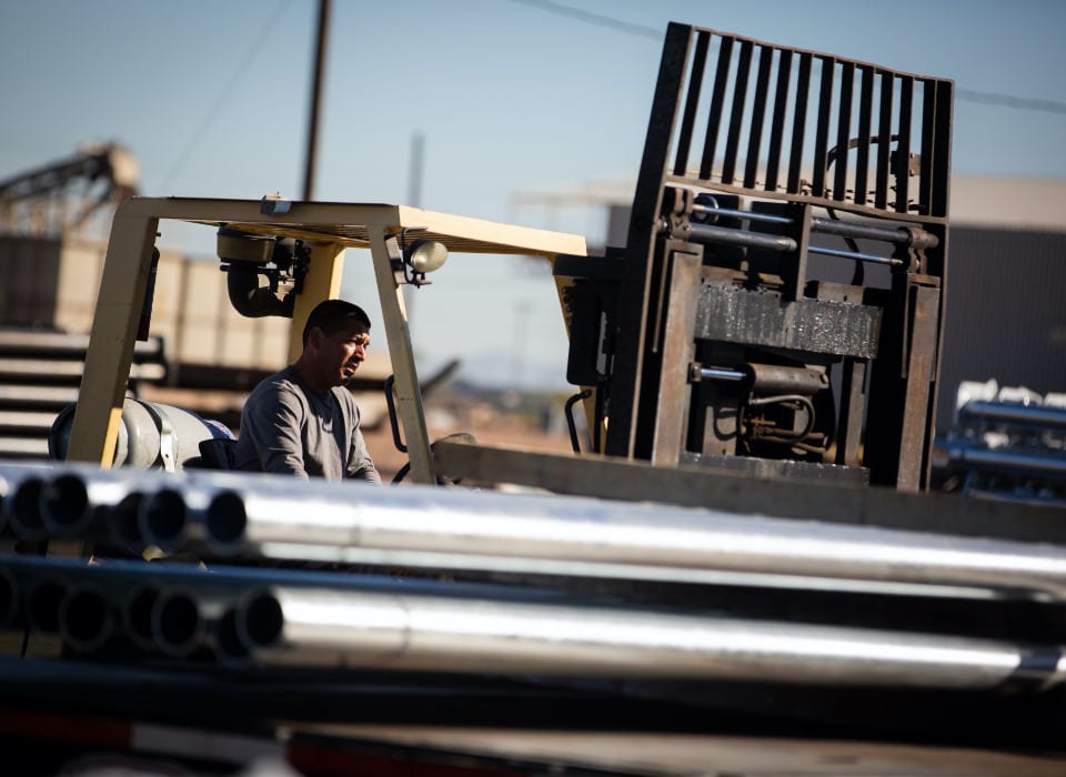 Man Forklifting Steel Light Poles